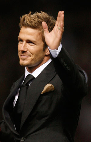 David Beckham waves to fans during the half-time break in a celebration soccer match between Manchester United and an Europe XI to mark the 50th anniversary of Manchester United appearing in European competition at Old Trafford in Manchester, northern England, March 13, 2007.