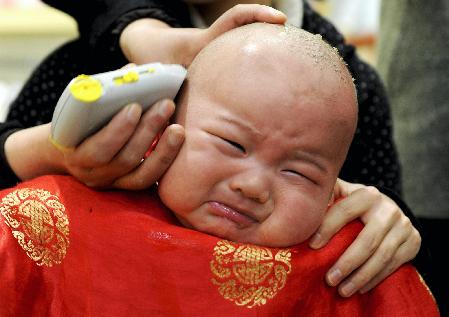 A child gets a haircut at a barbershop in Hefei