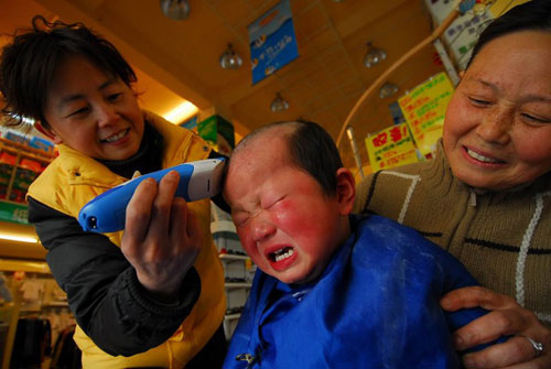 A child gets a haircut at a barbershop in Hefei